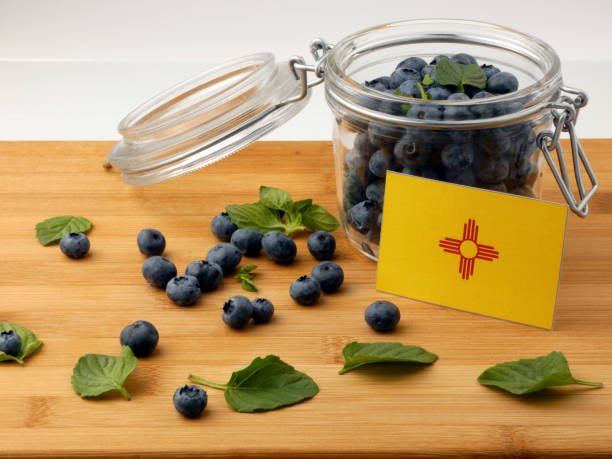 istock New Mexico flag on a wooden plank with blueberries isolated on white 842852870