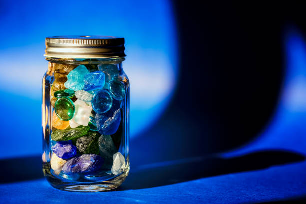 Jar full of colorful stones on a blue background