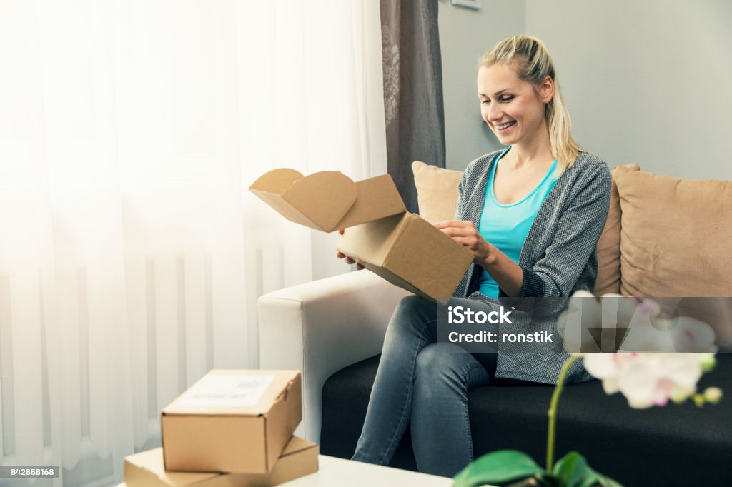 Hauszustellung - lächelnde junge Frau Eröffnung Karton - Lizenzfrei Öffnen Stock-Foto