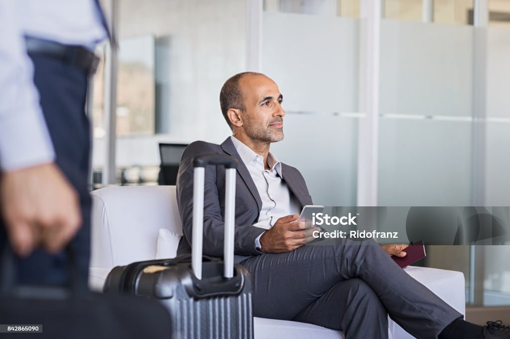 Uomo d'affari in attesa all'aeroporto - Foto stock royalty-free di Aeroporto