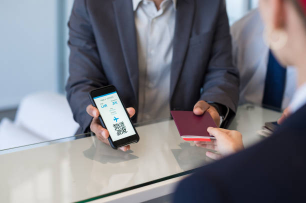Man showing electronic flight ticket Closeup hand of man showing flight ticket to staff on phone. Hostess checking electronic flight ticket. Airport check in counter and online air ticket. airplane ticket photos stock pictures, royalty-free photos & images
