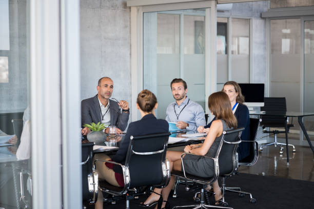 Business meeting Business people sitting in boardroom and working together at new strategy plan. Group of leader and businesspeople in a meeting at office. Senior executive with his team working in a conference room. staff meeting stock pictures, royalty-free photos & images