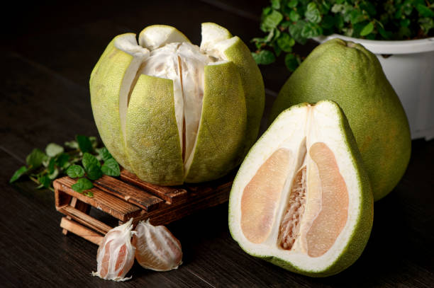 istock fresh grapefruit ,peeled grapefruit and grapefruit with slices on wooden table isolated on black background 842869854