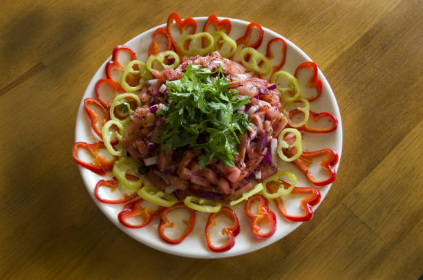 Salads and heart-shaped peppers on a wooden table