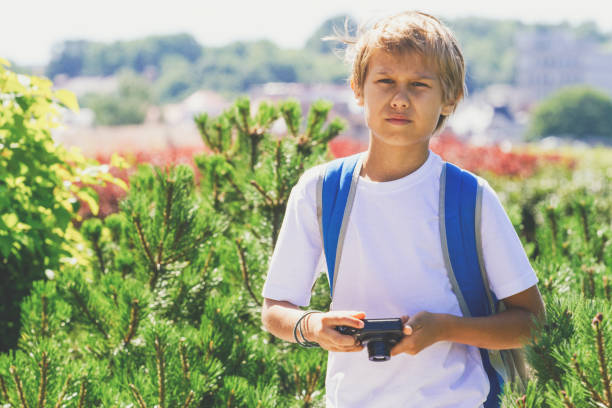 istock Young boy with a digital camera taking pictures outdoor 842879370