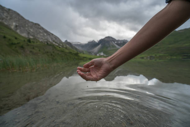 istock Human hand cupped to catch fresh water from mountain lake 842882476