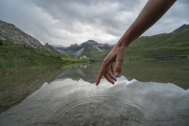 istock Human hand cupped to catch fresh water from mountain lake 842883948