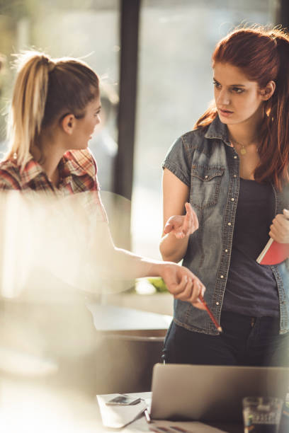 istock Two female freelance workers discussing in the office. 842890124