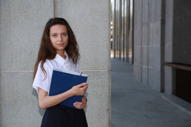 istock Girl student holding a folder in hands, college student, a school, 842894466