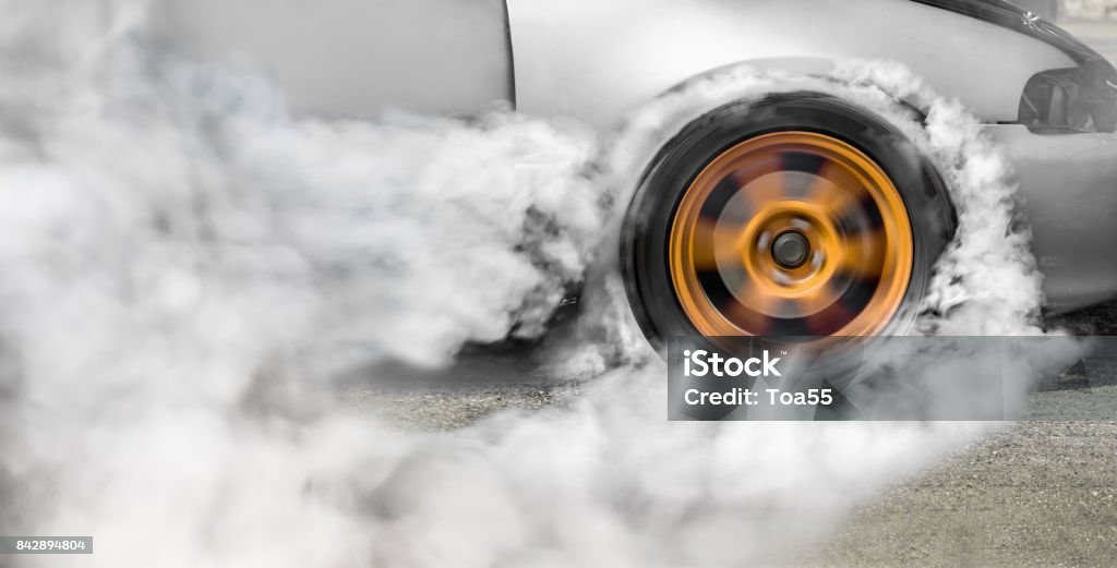 Drag racing car burns rubber off its tires in preparation for the race Tire - Vehicle Part Stock Photo