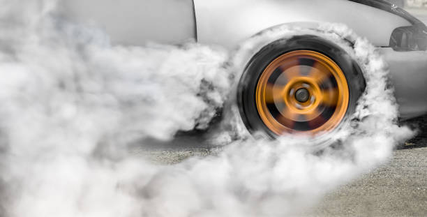 перетащите гоночный автомобиль сжигает резину с шин в рамках подготовки к гонке - drag racing стоковые фото и изображения