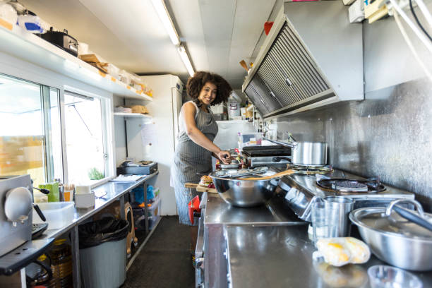 istock Smiling female food van worker making sandiches 842895010