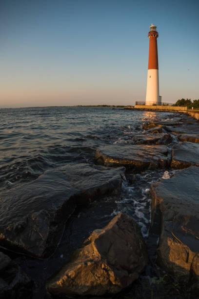 sonnenuntergang am leuchtturm barnegat lighthouse - meeresarm stock-fotos und bilder