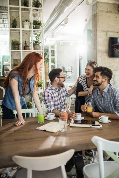 istock Group of young cheerful friends talking in a cafe. 842899748