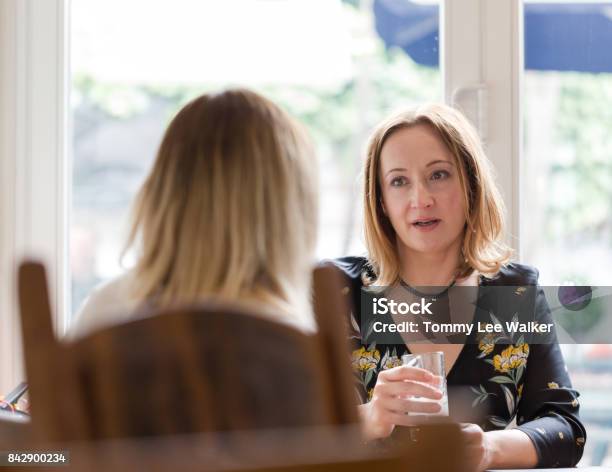 Two Young Adult Women Having Friends Chat In Pub Stock Photo - Download Image Now - Discussion, Serious, Talking