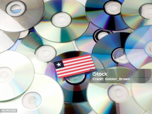 Liberian Flag On Top Of Cd And Dvd Pile Isolated On White Stock Photo - Download Image Now