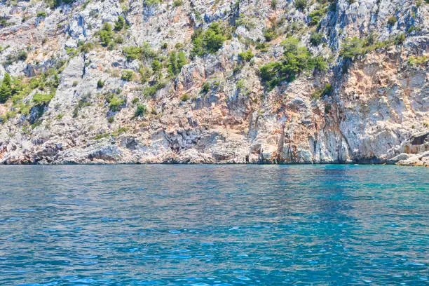 Photo of Cliffs at turquoise sea water with emerald hues. Adriatic coast of Hvar island, popular touristic destination at Croatian coast.