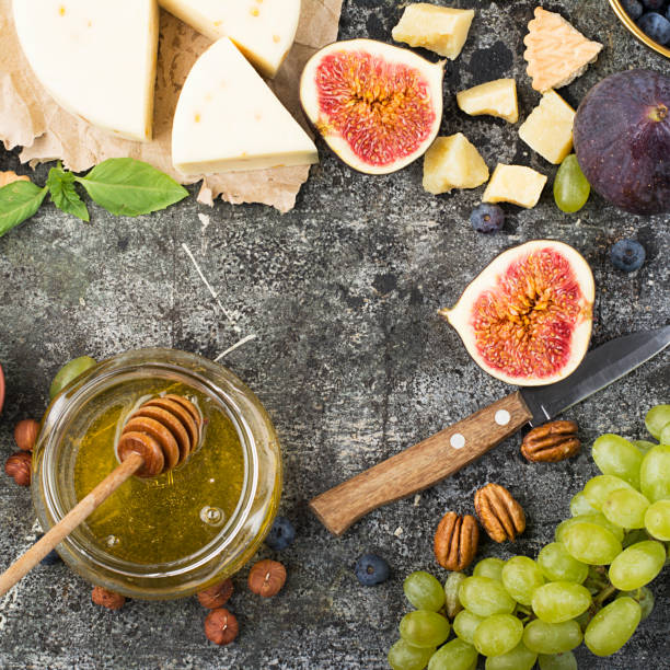 istock Cheese board for snacks, tricks, meetings with friends, on a gray stone background: assorted cheeses, young cheese, parmesan, cheese with fenugreek, figs, nuts, honey, grapes Top View. 842905234
