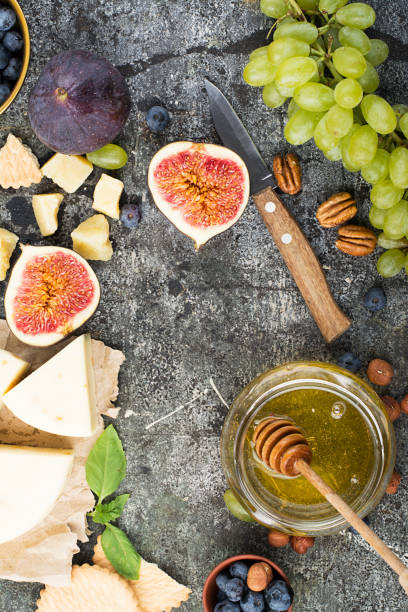 istock Cheese board for snacks, tricks, meetings with friends, on a gray stone background: assorted cheeses, young cheese, parmesan, cheese with fenugreek, figs, nuts, honey, grapes. Top View. 842906208