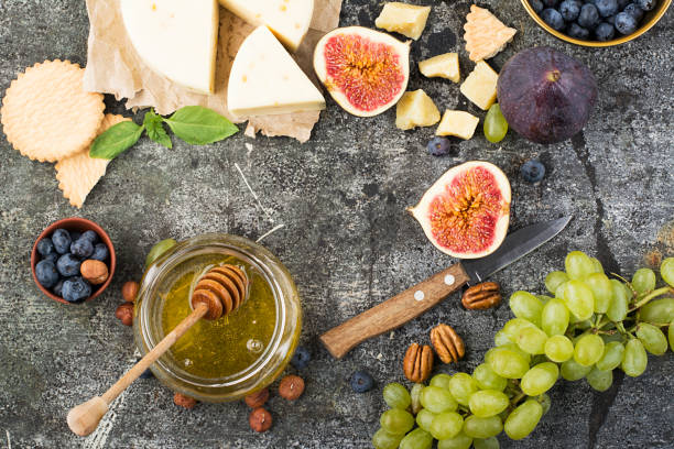istock Cheese board for snacks, tricks, meetings with friends, on a gray stone background: assorted cheeses, young cheese, parmesan, cheese with fenugreek, figs, nuts, honey, grapes. Top View. 842906214