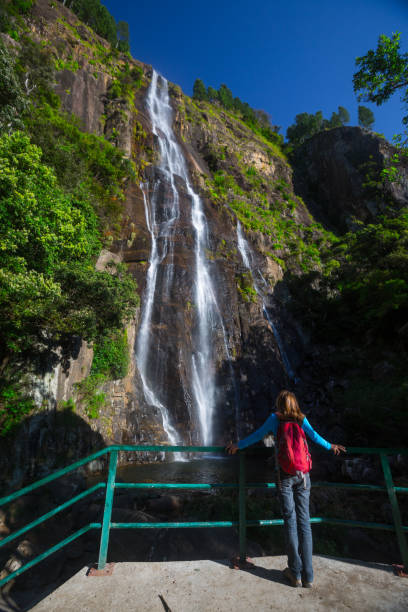 istock Woman observs tropical waterfall 842906354