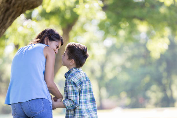 istock Mom and son walk together in a park 842906430