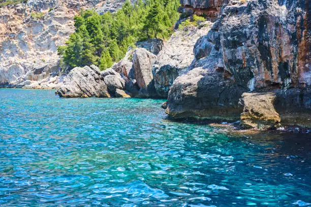 Photo of Cliffs at turquoise sea water with emerald hues. Adriatic coast of Hvar island, popular touristic destination at Croatian coast.