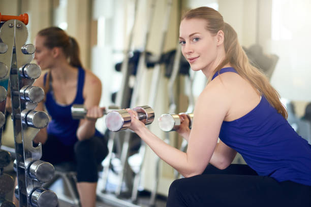 fit gesunde frau, die mit gewichten trainieren - fitnesscenter stock-fotos und bilder