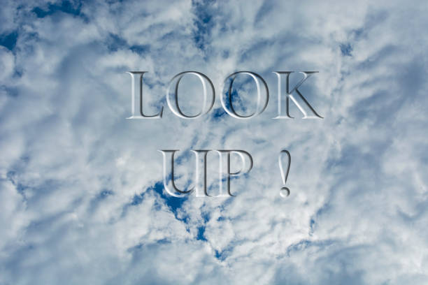 The sky with white clouds with the inscription Look up. Bottom view.