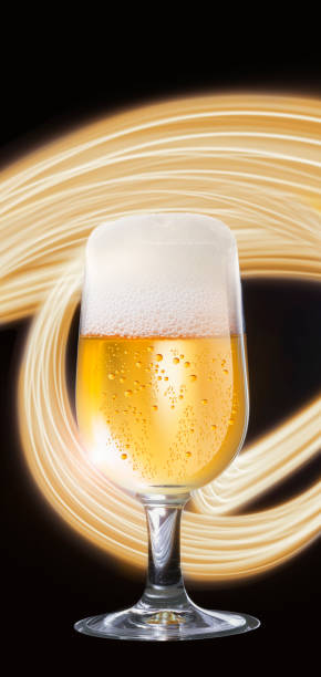 Beer glass with beer foam and light painting on black