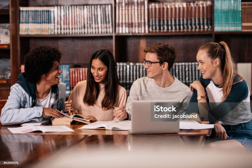 Heureux étudiants travaillant sur le projet d’Ecole en bibliothèque - Photo de Étudiant en université libre de droits