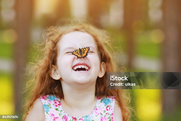 Lustig Lachen Lockiges Mädchen Mit Einem Schmetterling Auf Seiner Nase Stockfoto und mehr Bilder von Kind
