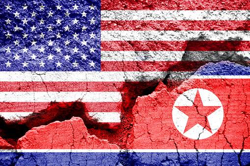 Flag of USA and North Korea on a cracked background. Concept of conflict between two nations, Washington and Pyongyang.