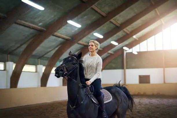 Photo of Woman in white jumper on a horse