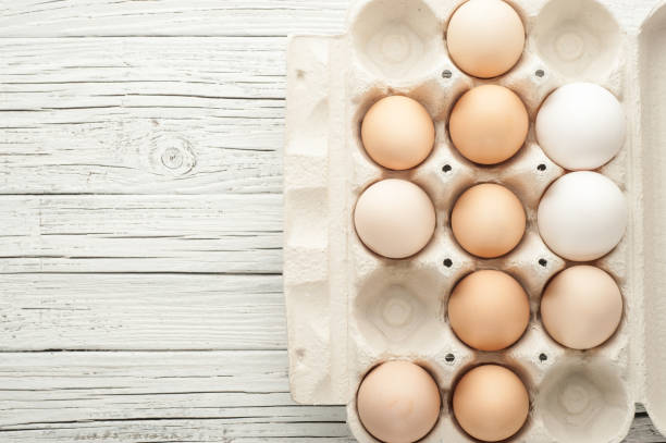 istock chicken eggs in cardboard box on white wooden background 842945692