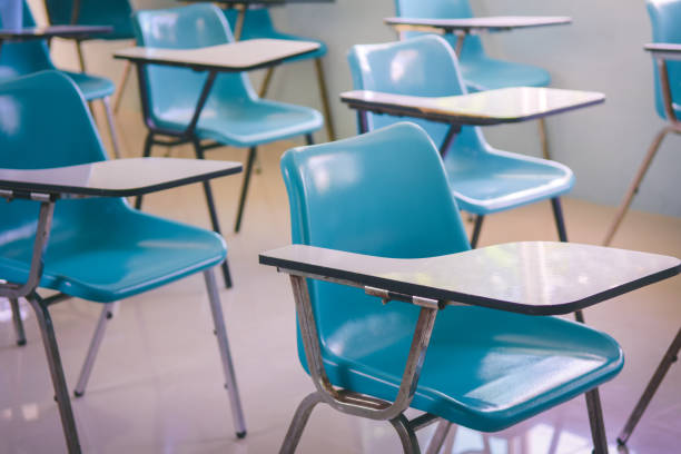 istock Empty classroom with chairs and desks in School or college . 842948262