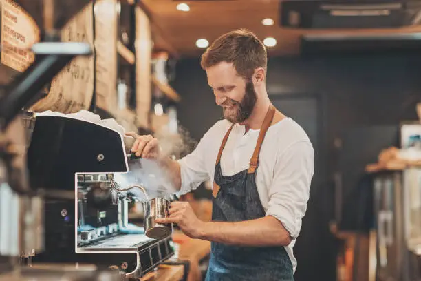 Photo of Male barista making cappuccino