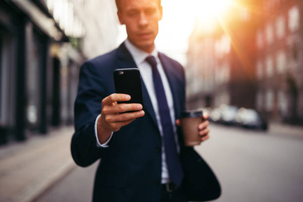 istock Young executive reading messages on his cellphone in the city 842950092