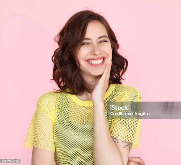 Brunette Woman In Yellow Shirt Smiling Stock Photo - Download Image Now - Women, Wavy Hair, Smiling