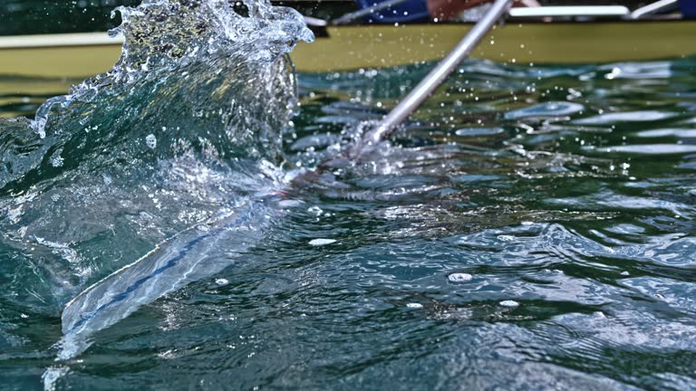 SLO MO Oar blade striking the water and making a splash in sunshine