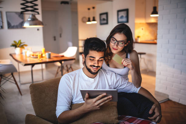 Everything you need is online Photo of a young couple shopping online over digital tablet. friends playing cards stock pictures, royalty-free photos & images