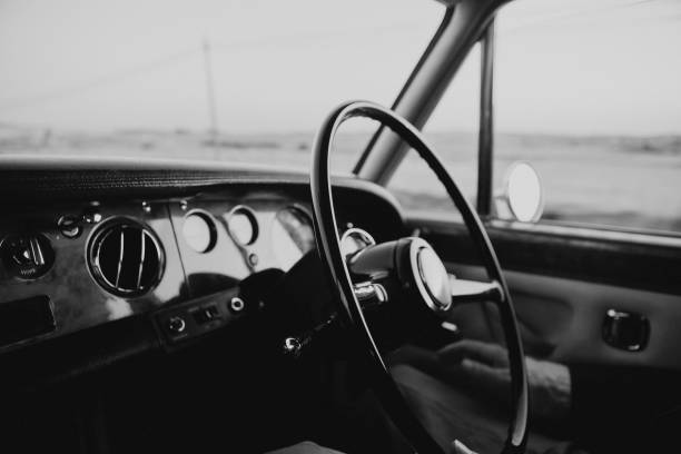 classic and luxury car dashboard with steering wheel in main focus. black and white style - collectors car antiquities ancient past imagens e fotografias de stock