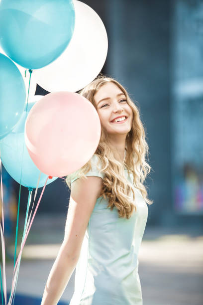 istock beautiful woman with flying multicolored balloons 842987476