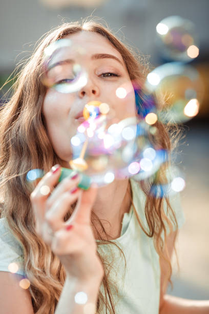 istock happy woman blowing soap bubbles 842997228