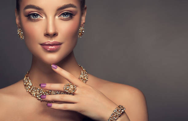 magnífica senhora em uma maquiagem perfeita é conjunto de joias de espectáculos. - gold jewelry earring bracelet - fotografias e filmes do acervo