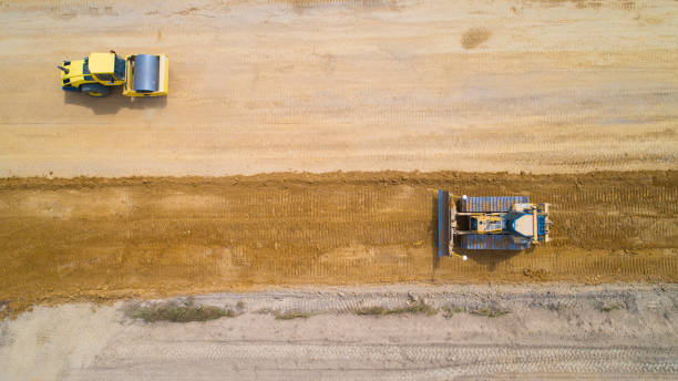 Aerial photo of a steam roller and a backhoe on a roadwork in Rouans, France stock photo
