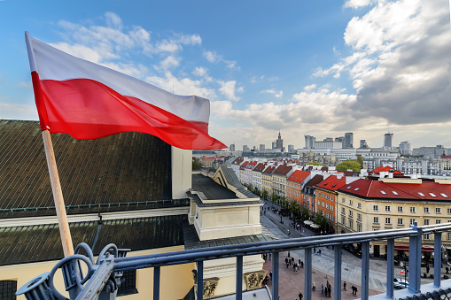 Poland Flag in Blue Sky and the centre of Warsaw in background