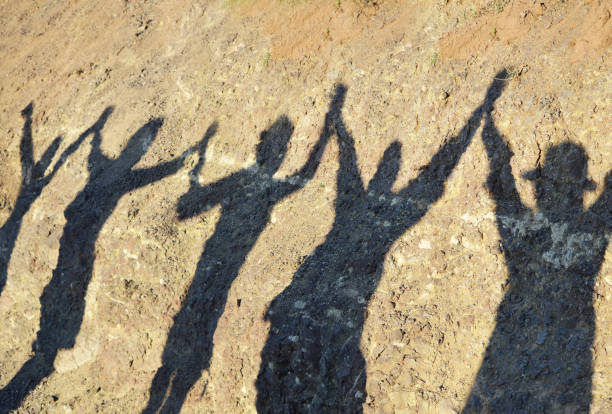 conceptos de unidad y éxito y la amistad, sombra de grupo de mujeres con las manos después de terminar de senderismo en la montaña - strong shadows fotografías e imágenes de stock