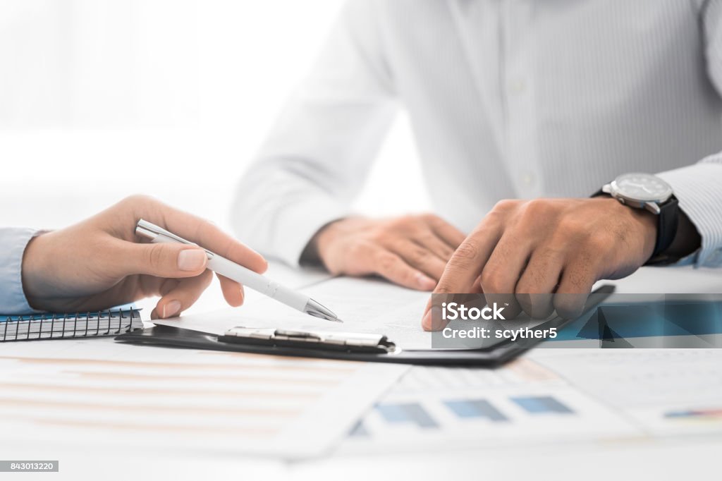 Business people negotiating a contract. Business people negotiating a contract. Human hands working with documents at desk and signing contract. Chance Stock Photo
