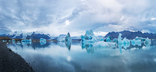 Multipxel panorama of the Glacier lagoon in Iceland. Picture taken at sunset with dramatic sky. Big chunk of ice swimming in the water.